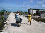 Cindy hauling a wheelbarrow of sand